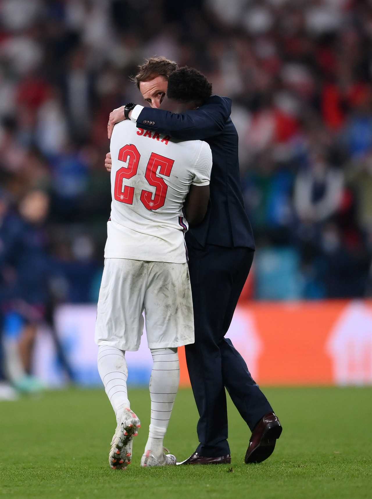 LONDON, ENGLAND - JULY 11: Bukayo Saka of England is consoled by Head Coach, Gareth Southgate after his penalty miss during the UEFA Euro 2020 Championship Final between Italy and England at Wembley Stadium on July 11, 2021 in London, England. (Photo by Laurence Griffiths/Getty Images)