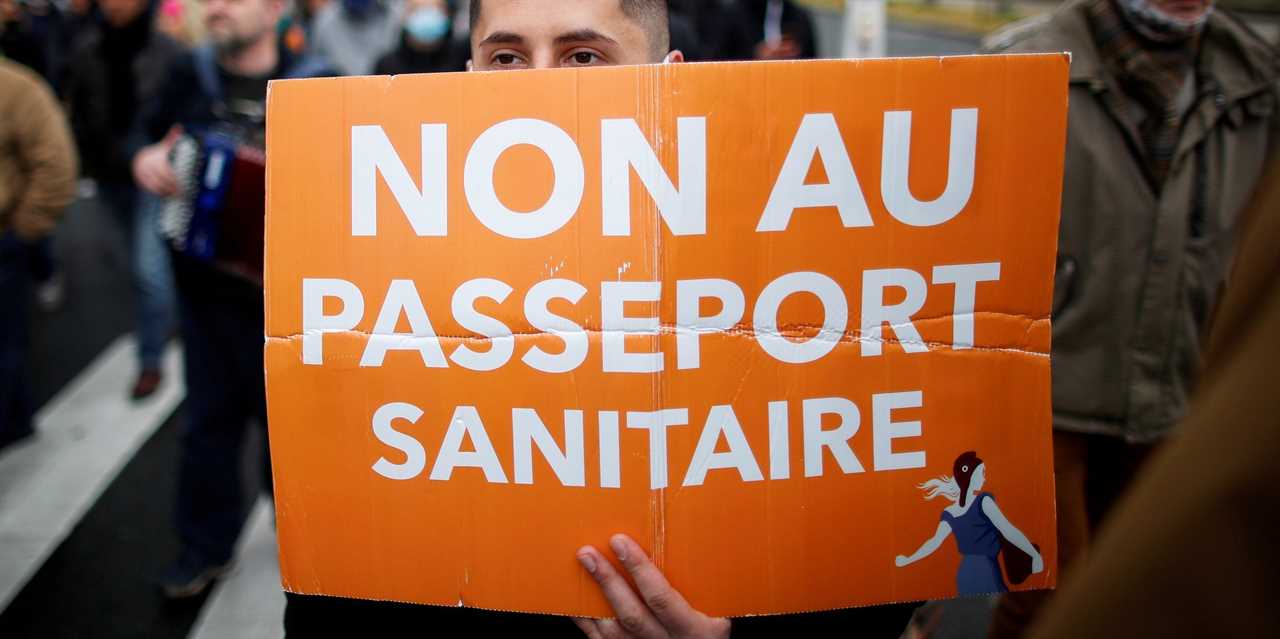 A supporter of French nationalist party "Les Patriotes" (The Patriots) holds a placard during a protest against government's economic and social policies during the coronavirus disease (COVID-19) outbreak in Paris, France April 10,2021. The placard reads "No to the health passport".
