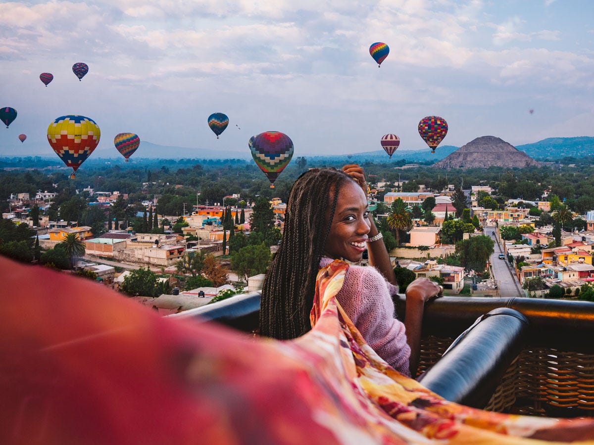 Black woman in hot air balloon overlooking Mexico City