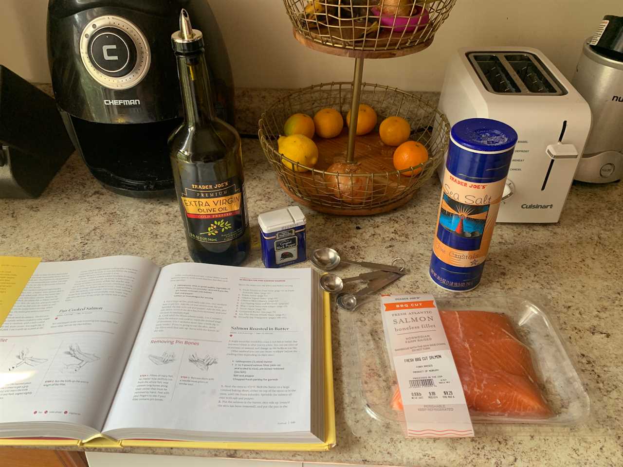 "How to Cook Everything" cookbook with salmon, teaspoons, salt, oil, and pepper