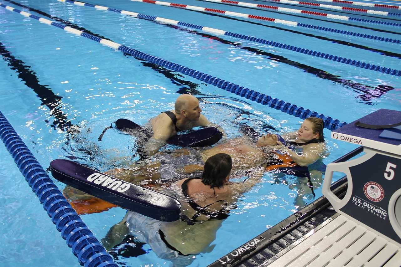 Olympic lifeguard James Meyer in the pool at the 2016 US Olympic swim trials with two swimmers