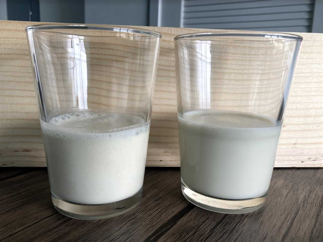 Two glasses of milk sitting on a wooden surface