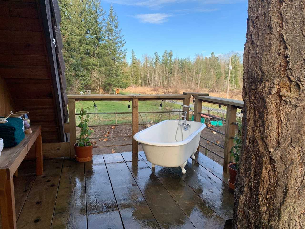 A porch with a tub on a farm stay on Airbnb.