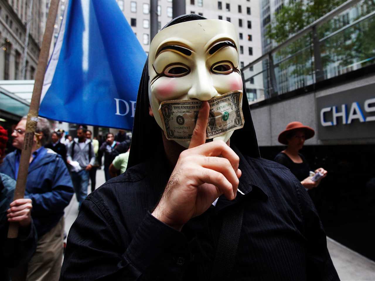 A man wearing a Guy Fawkes mask stands outside of a Chase Bank in Manhattan during the Occupy Wall Street protest.