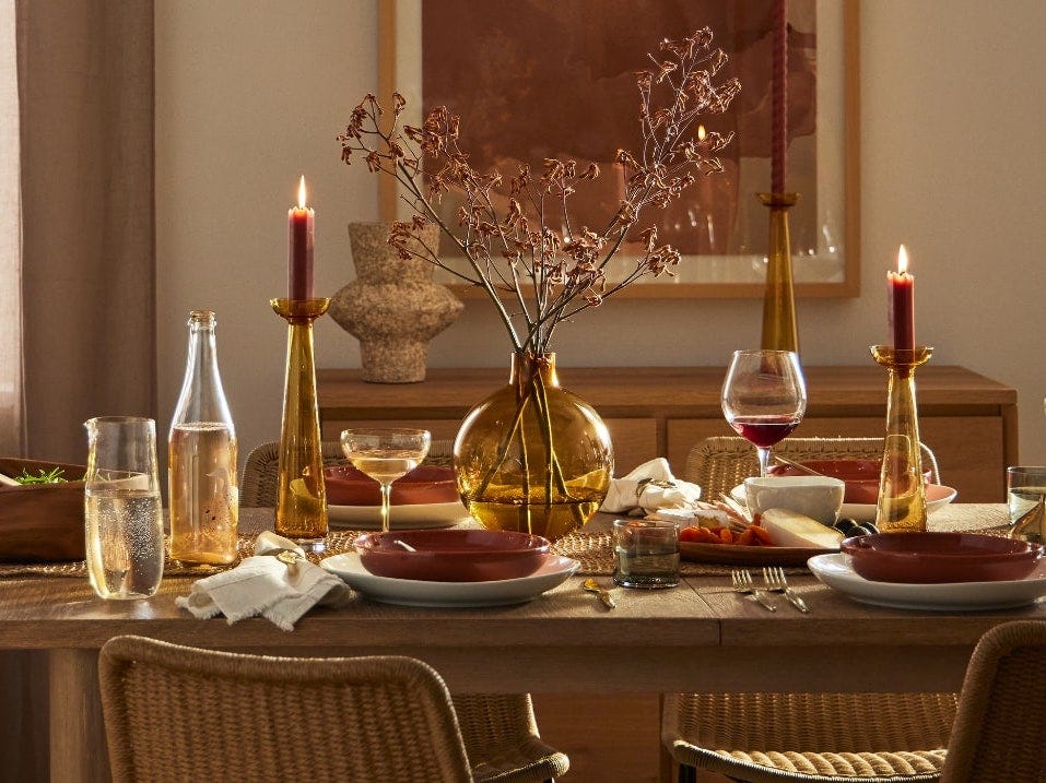 Image of a table decorated in glasses, candles, and centerpiece from West Elm best fall decor 2021