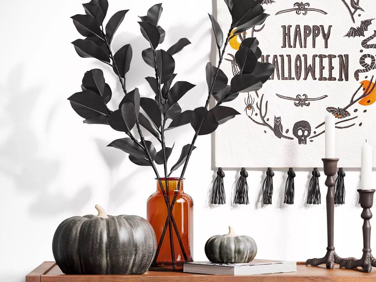 Image of a black pumpkin, candle holders, faux black leaves, and other Halloween decorations from Target, best Halloween decorations 2021