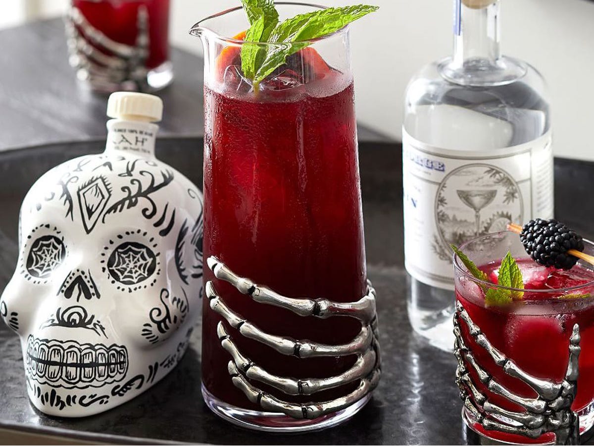Image of skeleton cocktail glasses, a skull-shaped bottle, and a bottle of alcohol, best Halloween decorations 2021