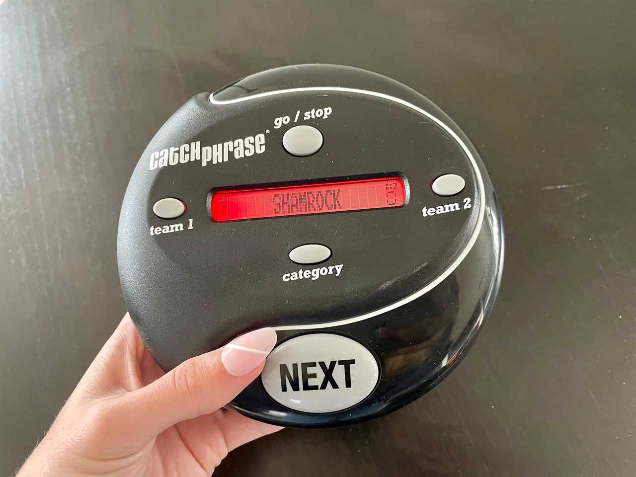 Image of the black handheld game Catch Phrase with word “shamrock” on the screen, best board games 2021