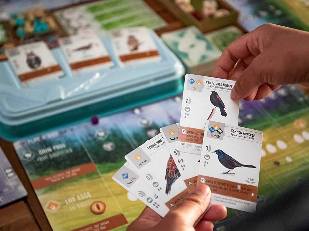 Image of five cards with birds on them and the board game wingspan in the background, best board games 2021