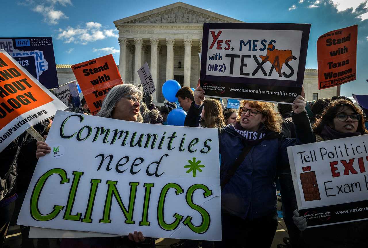 people supporting abortion rights hold signs saying 'communities need clinics' and 'yes mess with texas' outside the supreme court