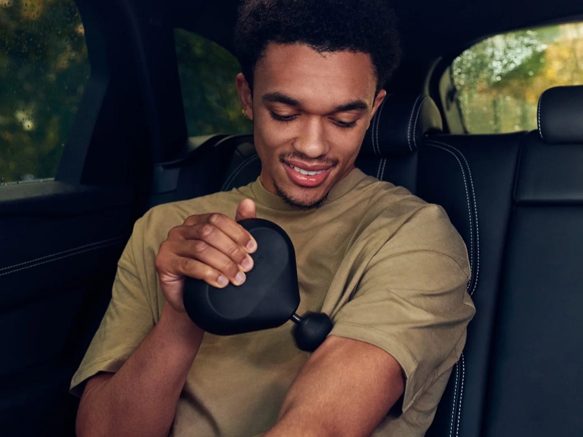 Image of a person using the Theragun Mini best anniversary gifts for him 2021