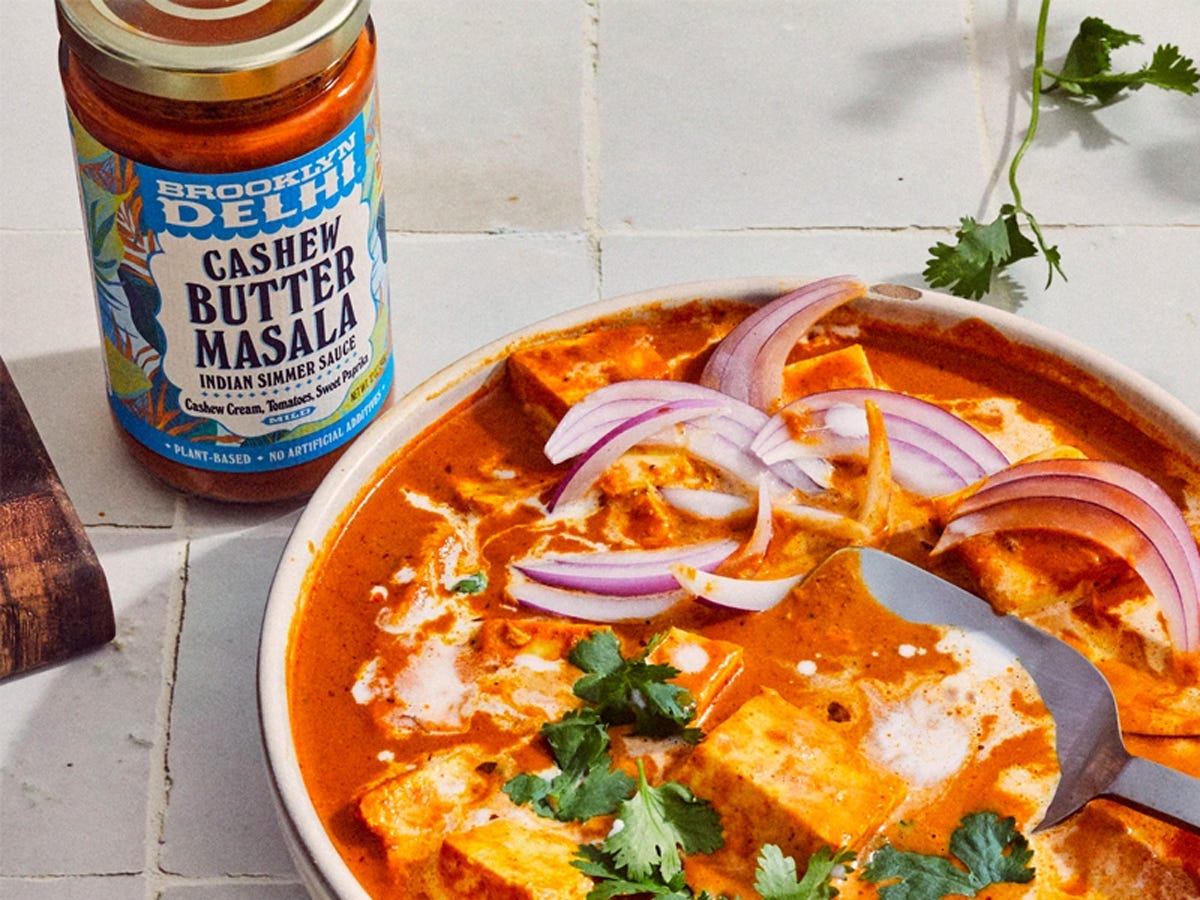 Bowl of cashew butter masala in front of jar from Brooklyn Delhi - Best Asian American food and drink brands