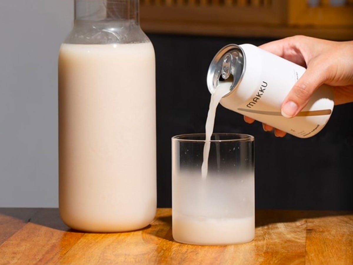 Hand pouring a can Makku Makgeolli Korean beverage into a glass - Best Asian American food and drink brands in 2021