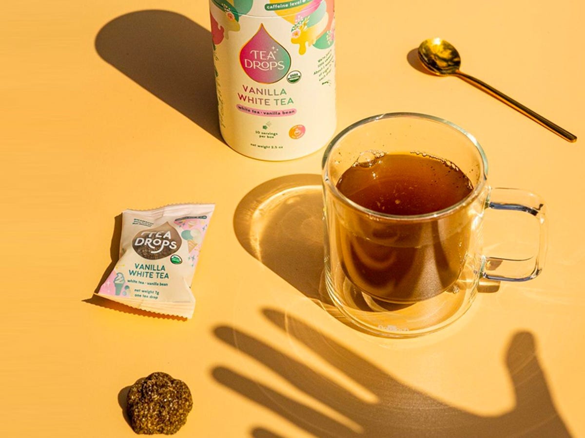 Shadow of hand reaching out to cup of tea from Tea Drops - Best Asian American food and drink brands in 2021