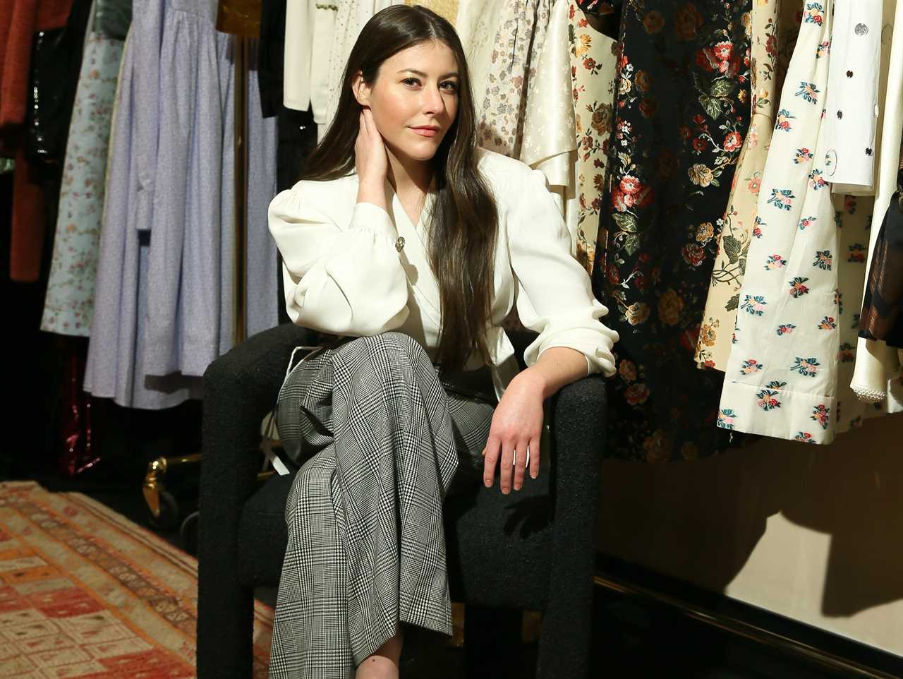 Markarian designer Alexandra O'Neill sits in front of clothes