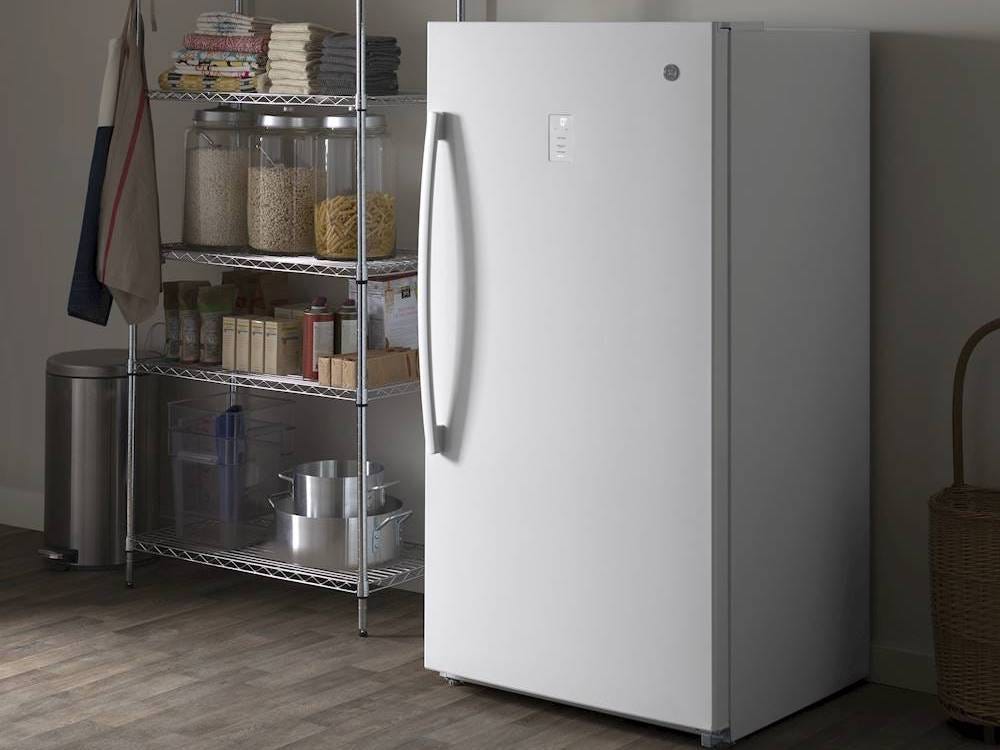 Image of the GE FUF17DLRWW freezer in a garage next to a shelf with pantry staples on it for best freezer of 2021