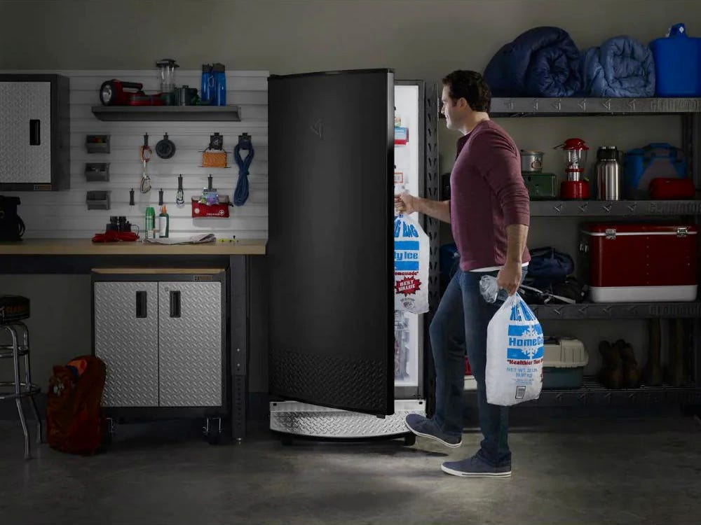 Image of a man putting bags of ice in the Gladiator GAFZ30FDGB freezer for best freezer of 2021