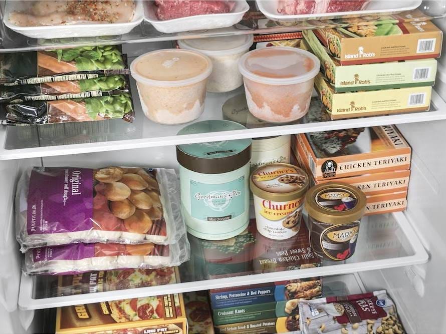 Image of the interior of a GE upright freezer with ice cream and other frozen foods arranged on the shelves, best freezers of 2021