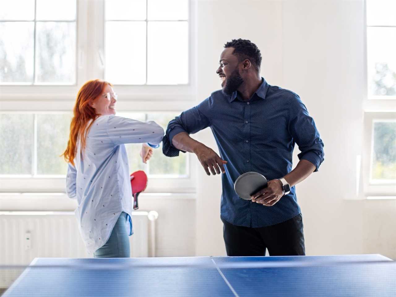 two friends hanging out, playing ping pong bumping elbows