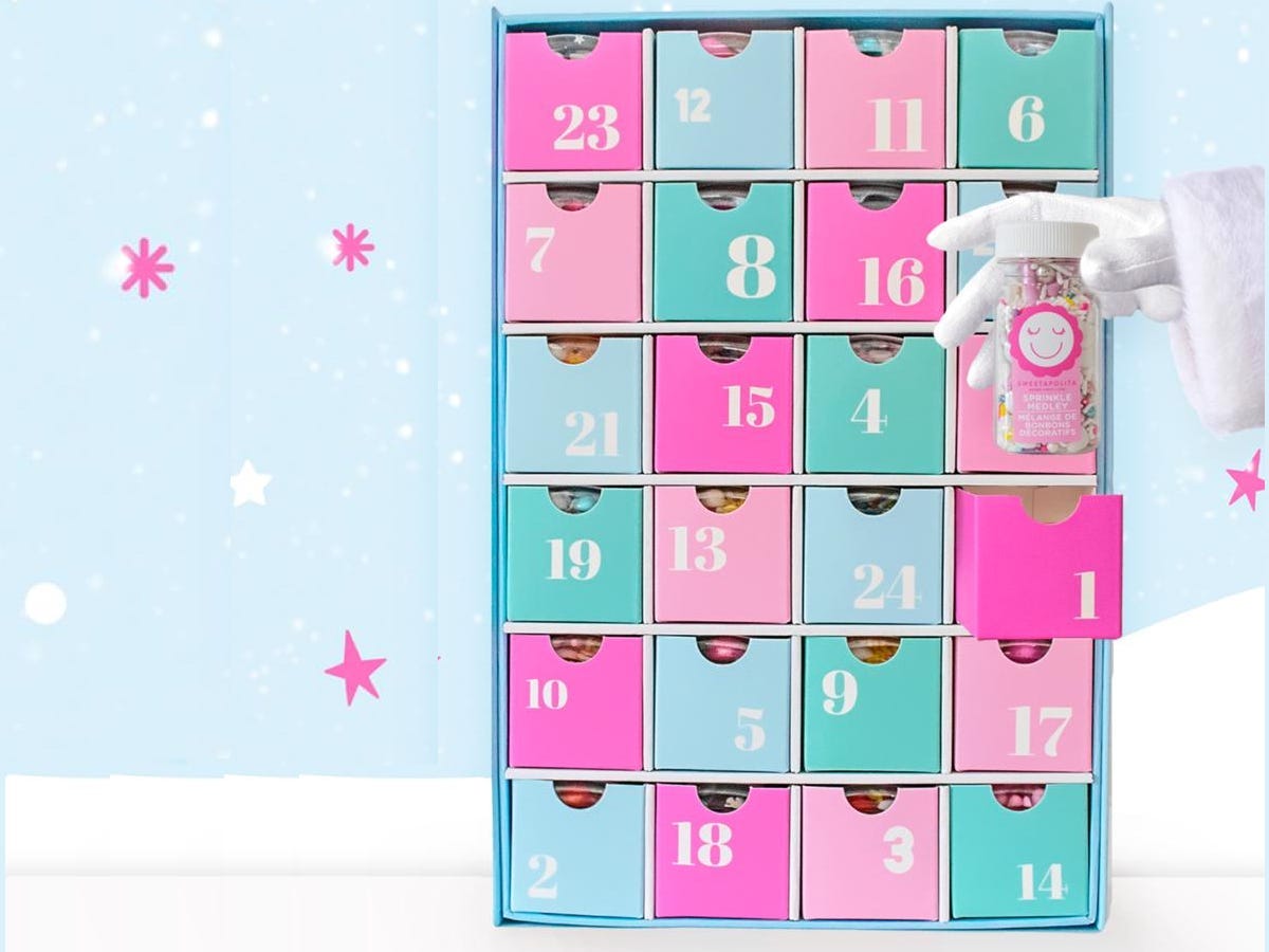 Image of gloved hand holding sprinkles in front of Sweetapolita sprinkle advent calendar for best advent calendars 2021