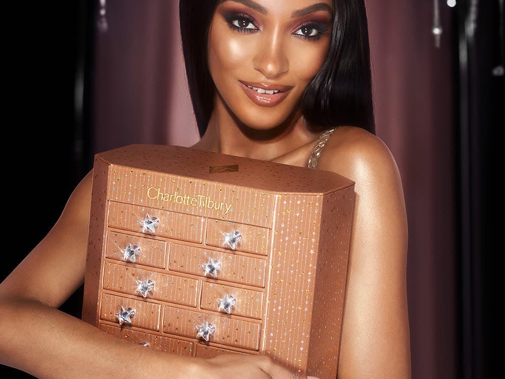 Image of woman holding Charlotte Tilbury advent calendar for best advent calendars 2021