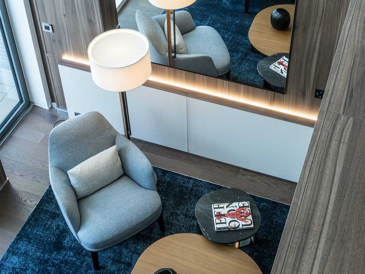 a lounge area next to a tall mirror