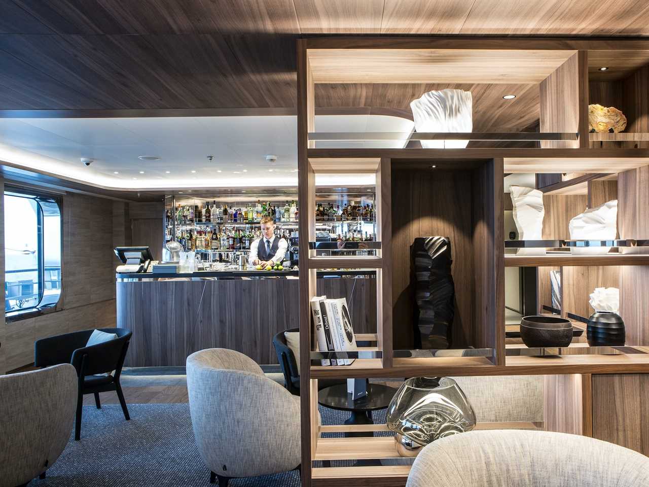 a bar behind a wall of shelves with decor