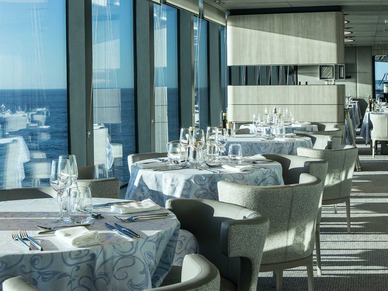 empty dining tables by floor-to-ceiling windows