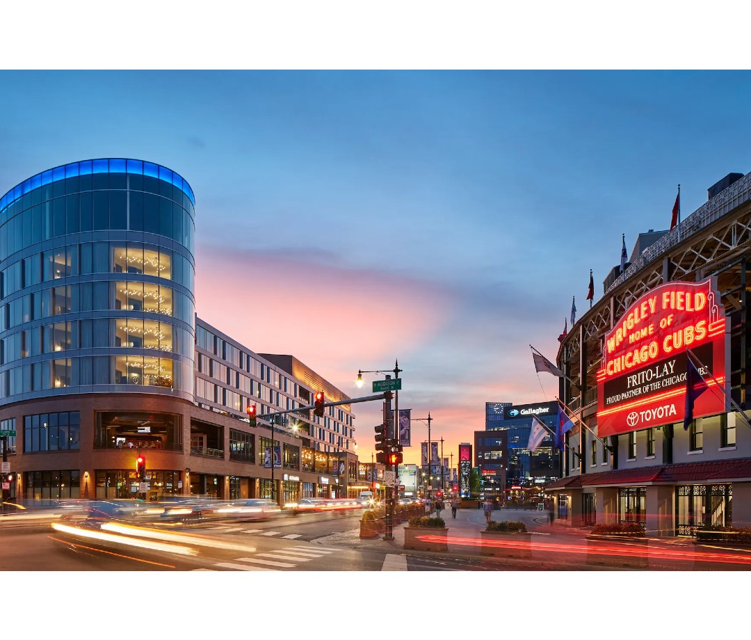 Hotel at sunset across from baseball stadium with red neon sign