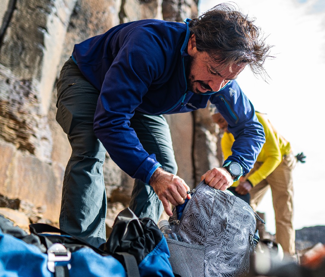 Hiker packing up his backpack at a campsite