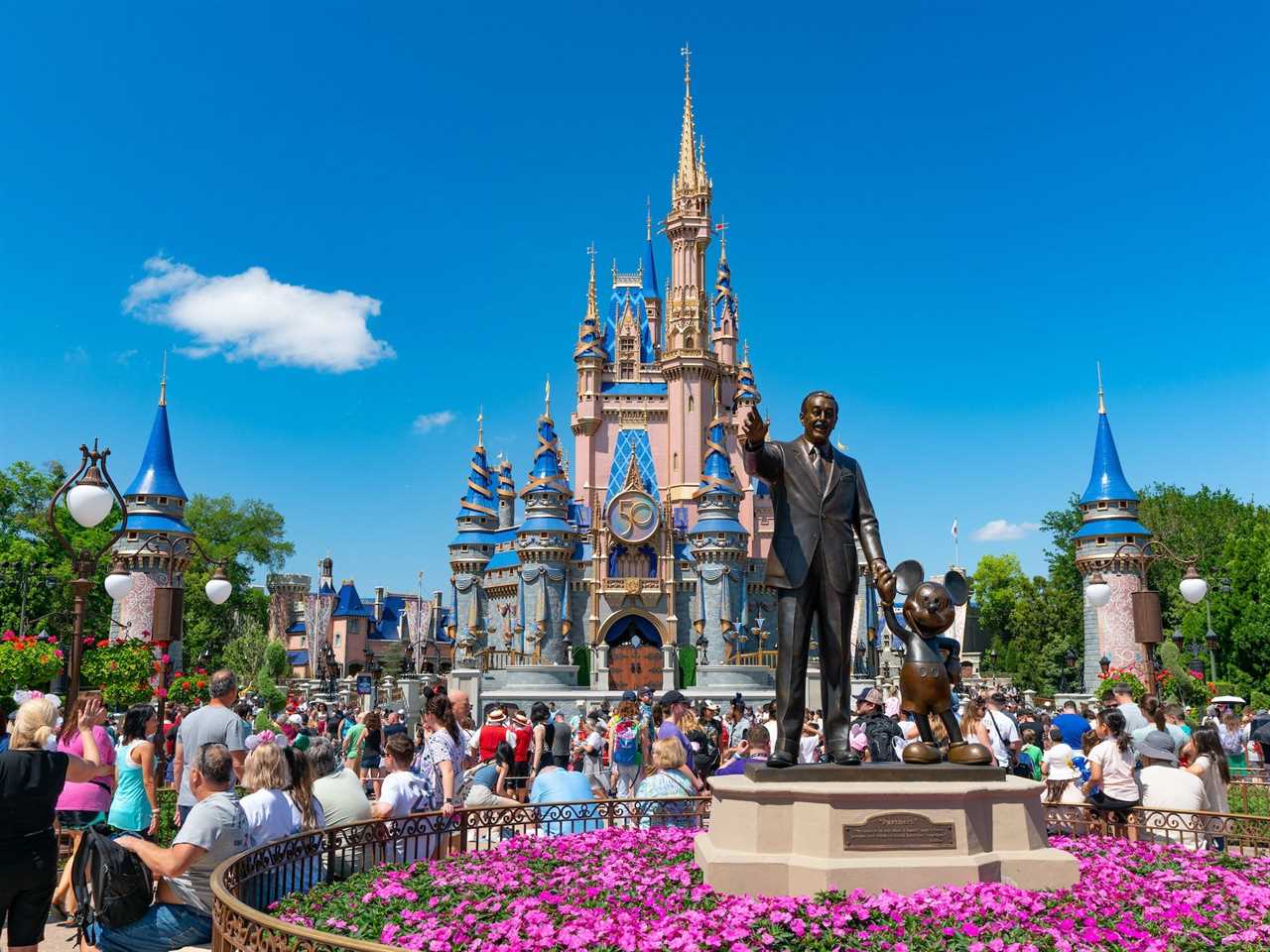 Photo of Walt Disney 'Partners' statue and people at Magic Kingdom in Florida.