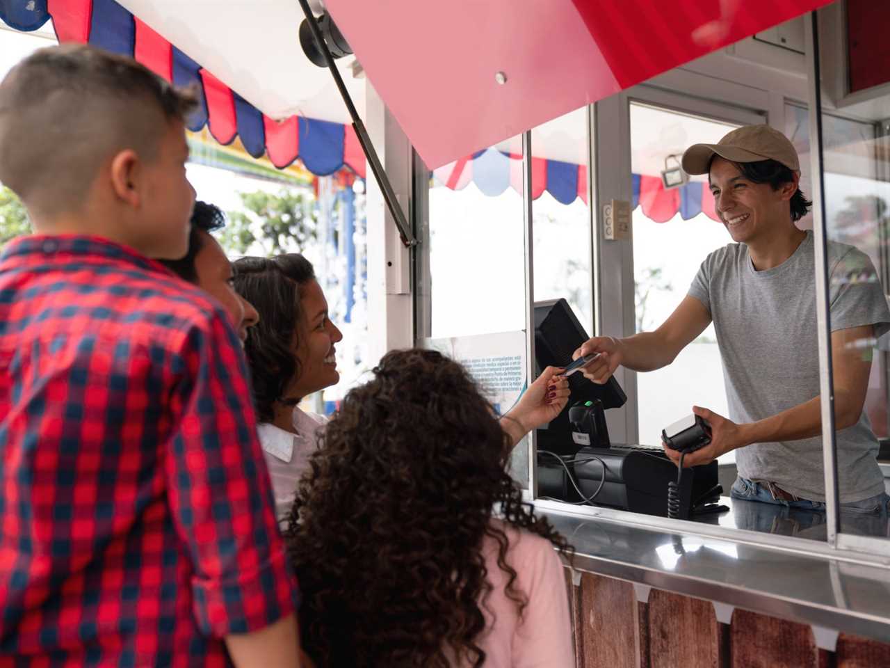 A family handing over a card to pay for food at an amusement park