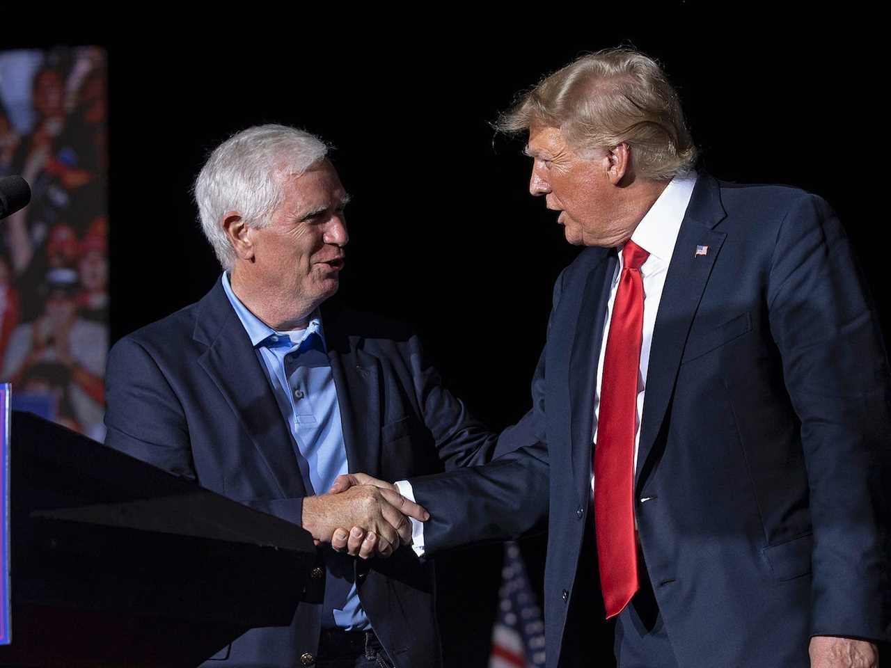 Republican Rep. Mo Brooks of Alabama shakes hands with then-President Donald Trump on stage at a political rally in Cullman, Alabama in August 2021.