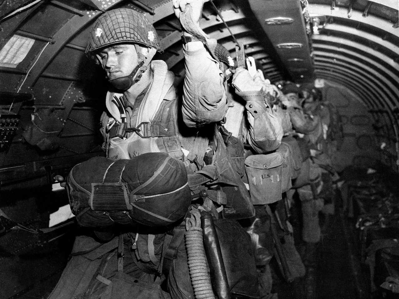U.S. paratroopers fix their static lines before a jump before dawn over Normandy on D-Day June 6, 1944, in France.