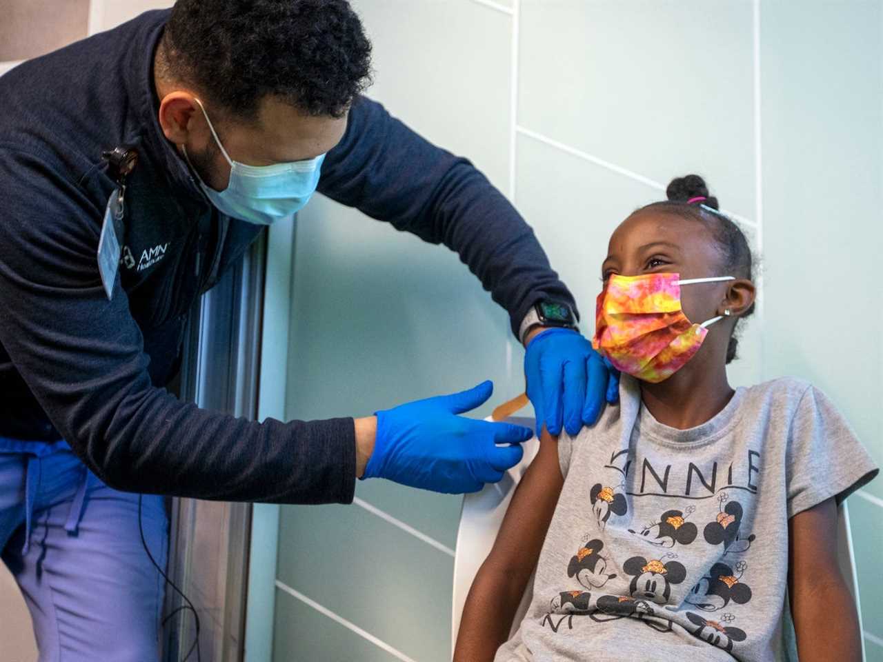 Nyla Varner, 9, Chino, right, receives a vaccination from Christopher King, 31, LVN, right, at Kaiser Permanente Tustin Ranch Vaccination Clinic on Thursday, Nov. 4, 2021 in Tustin, CA.