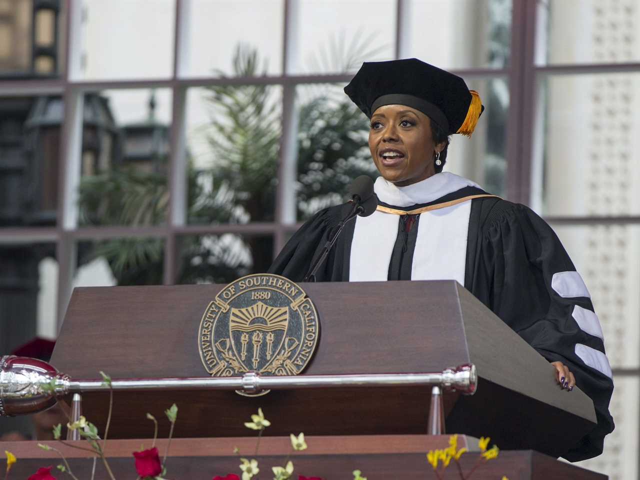 Mellody Hobson wearing graduation cap and gown standing at podium during USC graduation