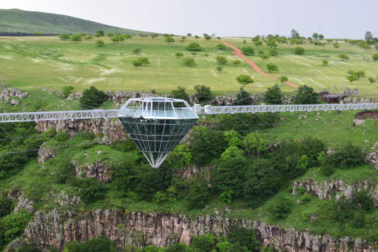 a glass bridge and diamond-shaped bar in the middle, suspended over the Dashbashi Canyon in Georgia