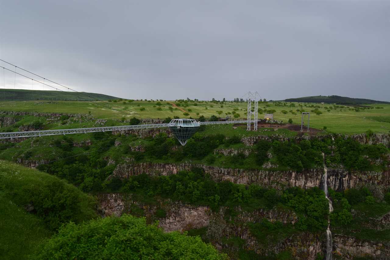 a glass bridge and diamond-shaped bar in the middle, suspended over the Dashbashi Canyon in Georgia