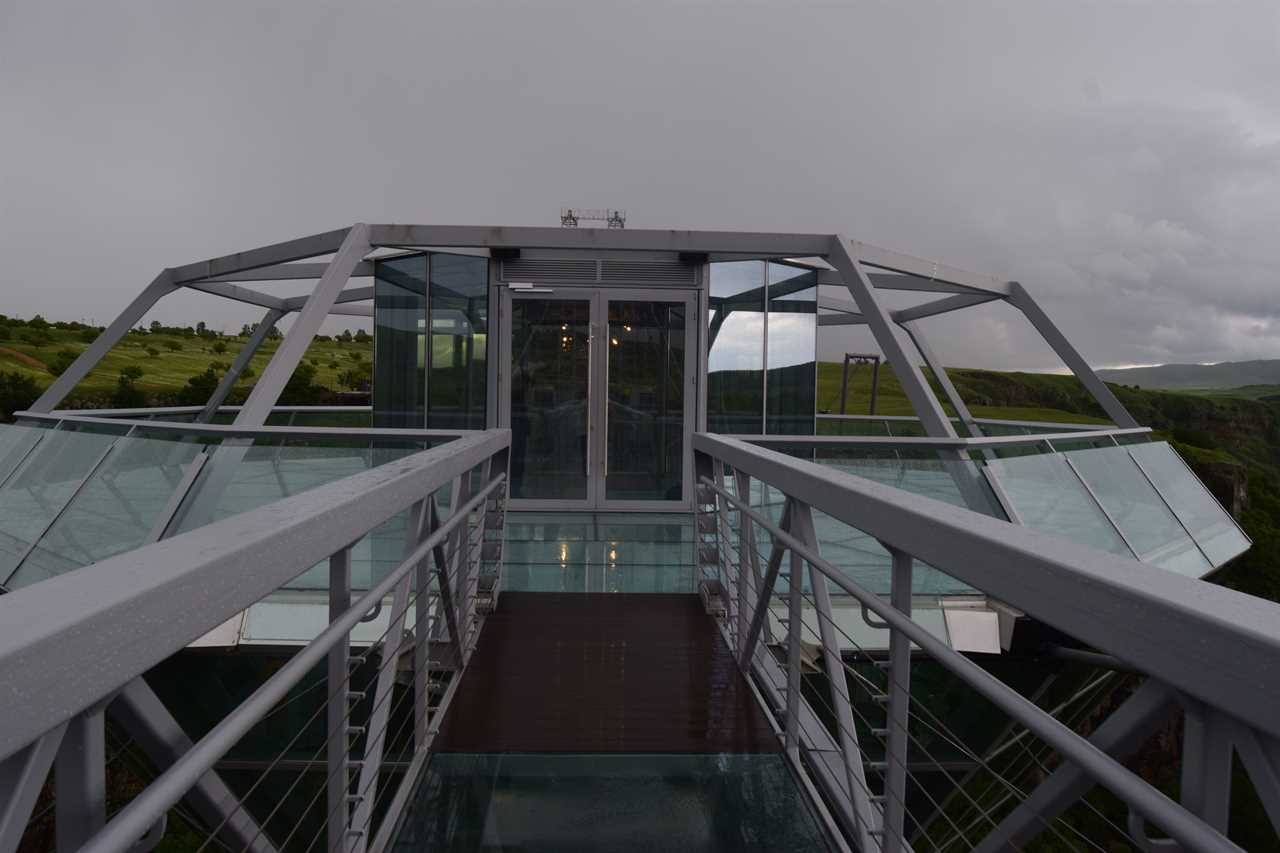 a glass bridge and diamond-shaped bar in the middle, suspended over the Dashbashi Canyon in Georgia
