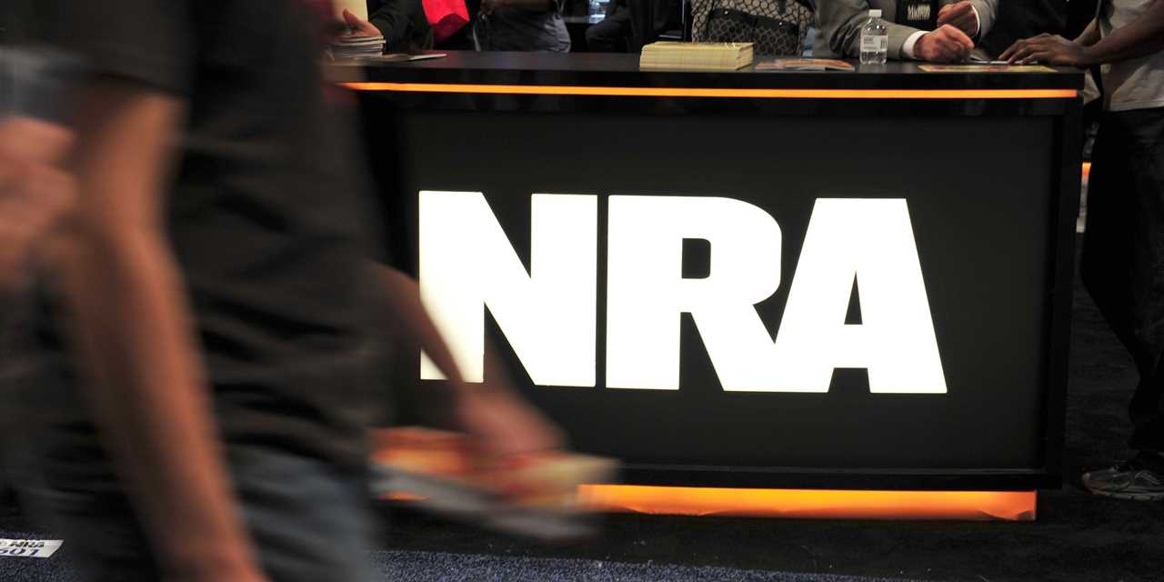 A convention goer passes the NRA desk at the 2015 NRA Annual Convention.
