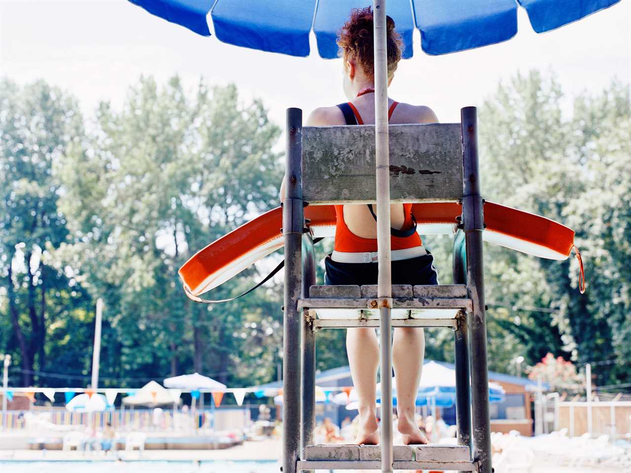Lifeguard sits in a chair watching an