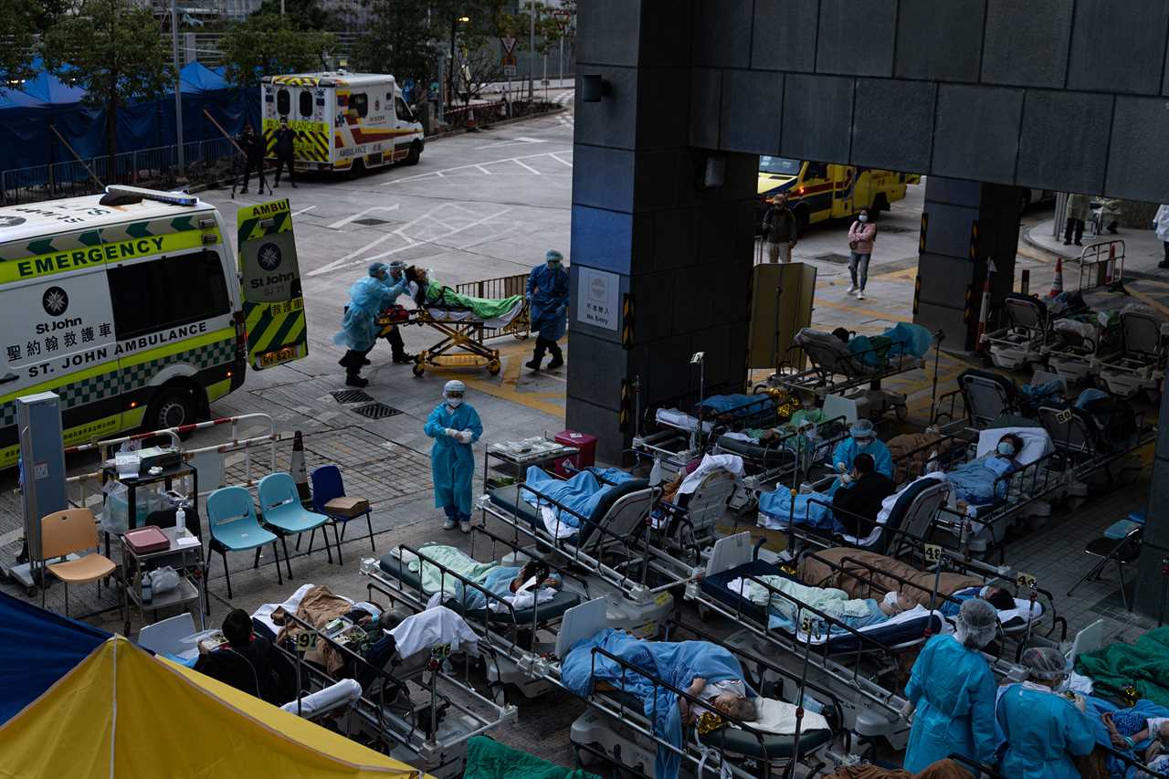 Patients lay in a temporary holding area outside Caritas Medical Center in Hong Kong on Feb. 16, 2022.