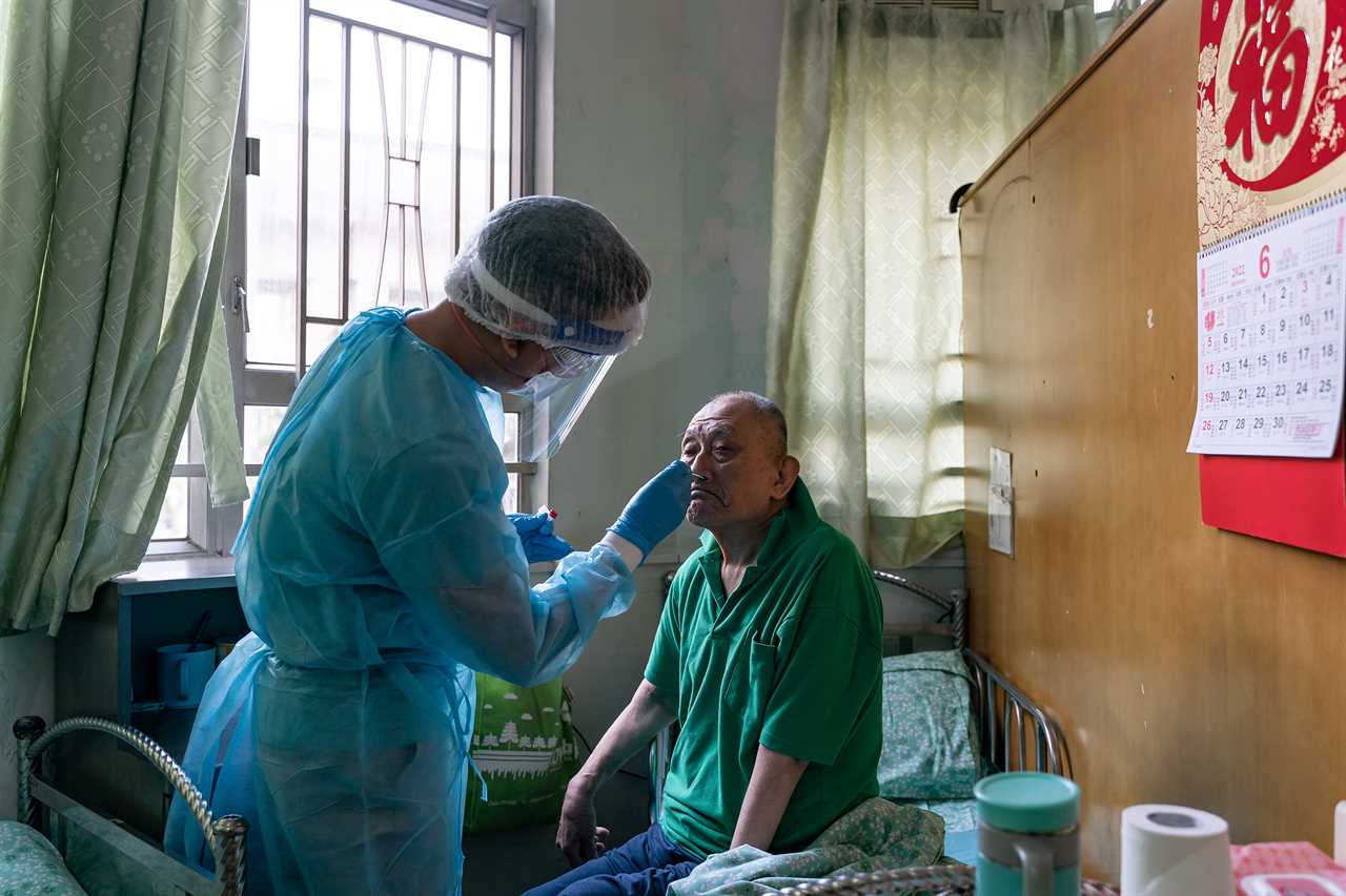 Dr. Poon Yui Pan, deputy head of Kei Tak (Tai Hang) Home For The Aged, takes sample from resident Mr. Yung for a Rapid Antigen Test.