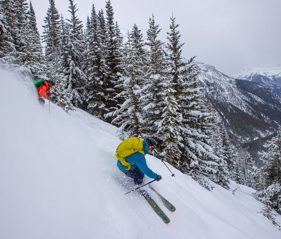 Skiers in colorful jackets skiing down slopes