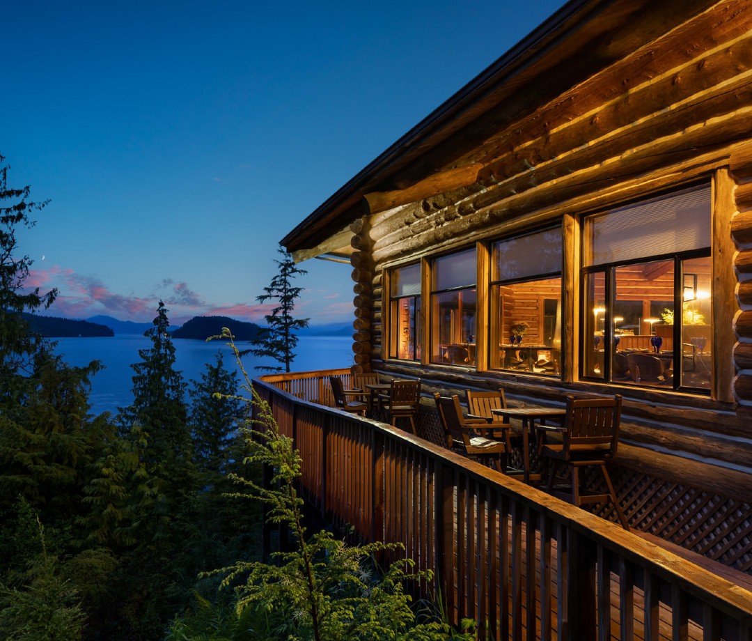 Log cabin near water at sunset