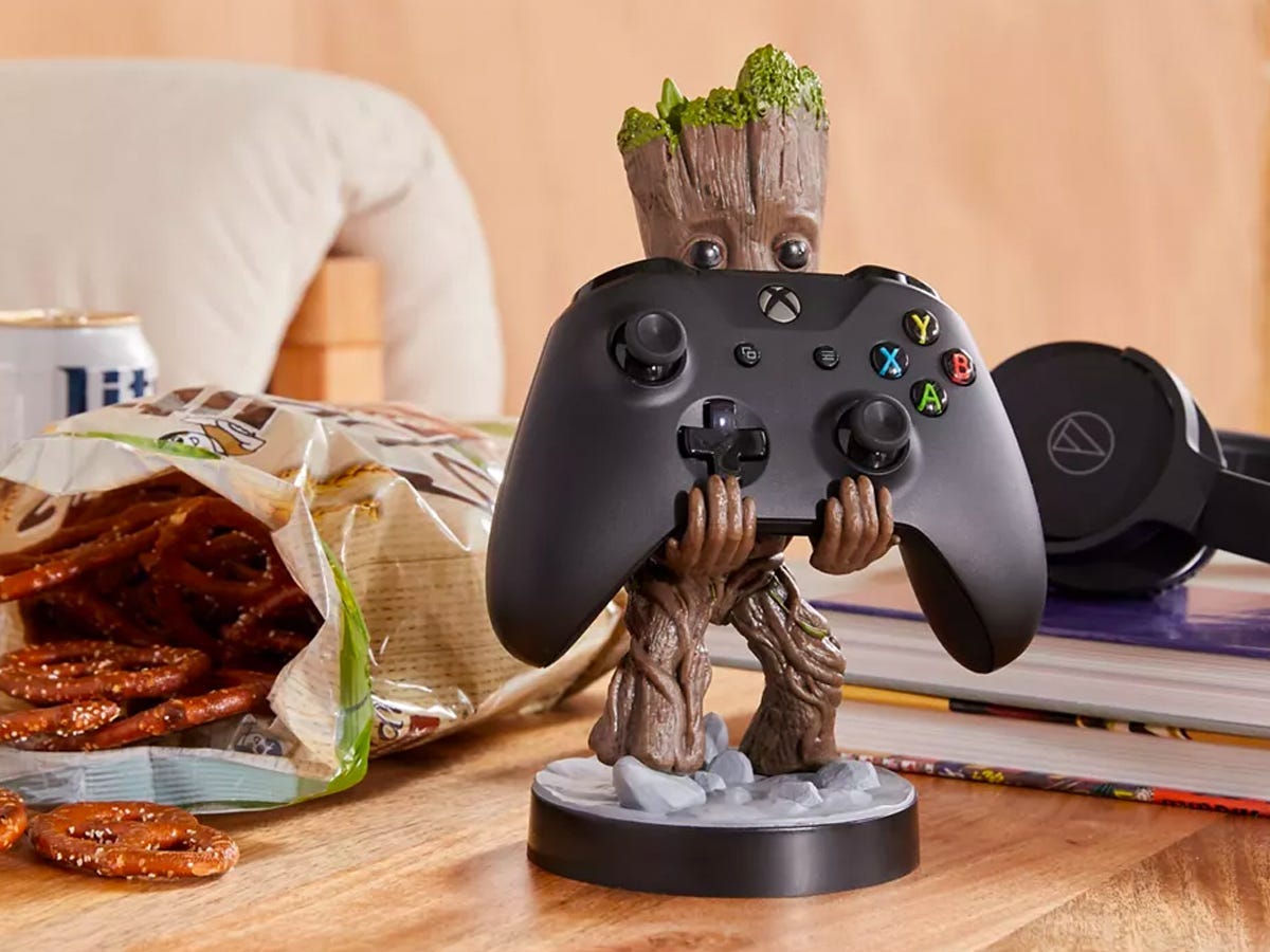 toddler Groot device holder holding an XBox controller