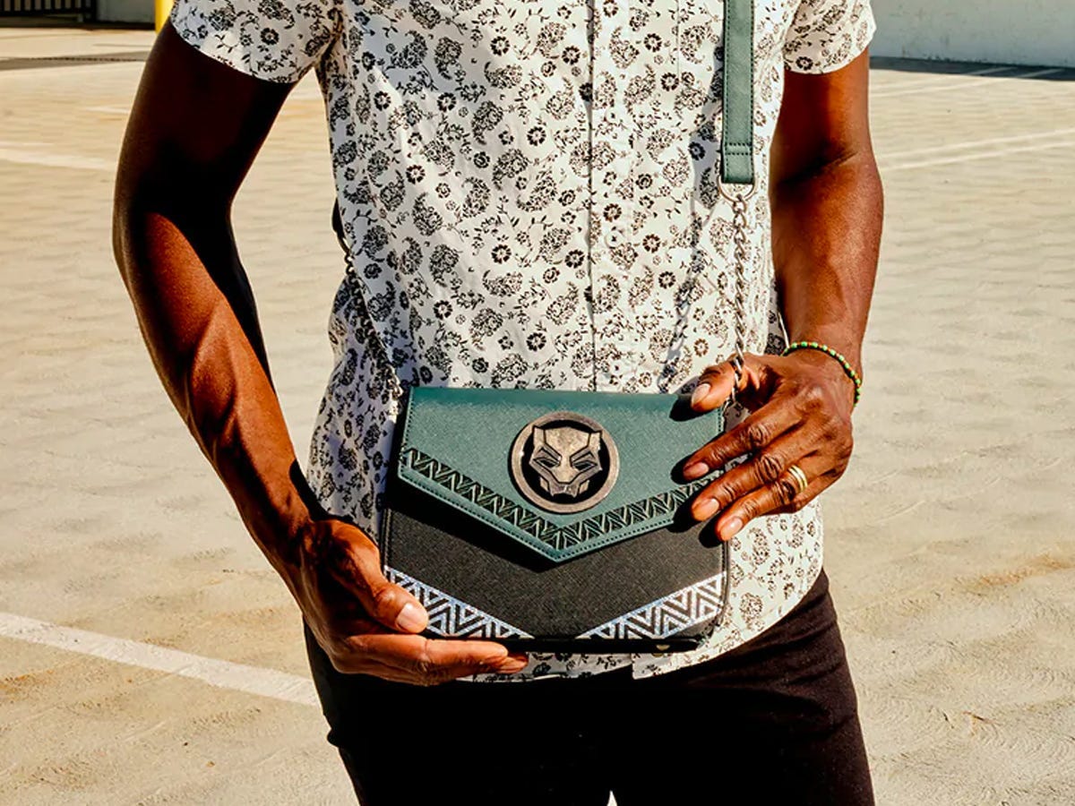 Person holding a "Black Panther: Wakanda Forever" themed crossbody bag