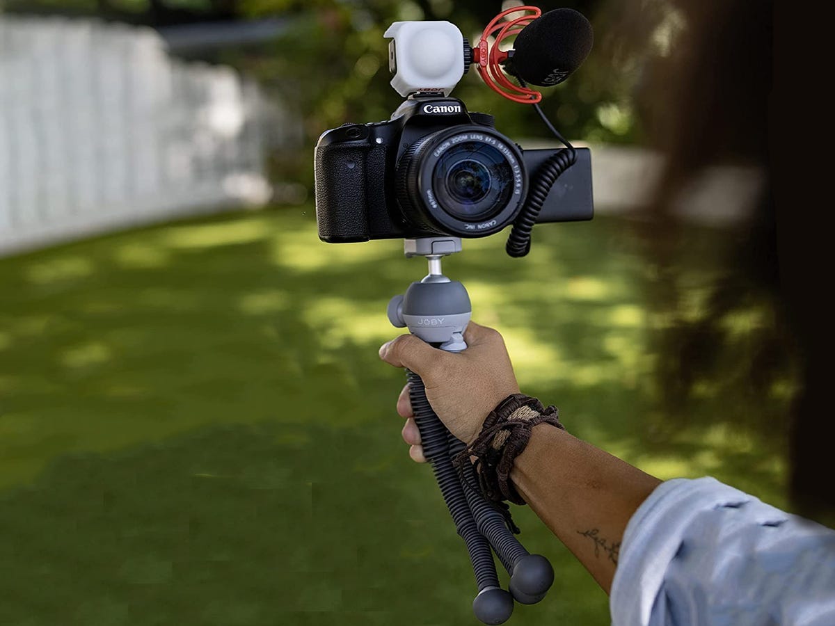 a person holds a camera on a Joby Podzilla Tripod outside as one of the best tech products under $50