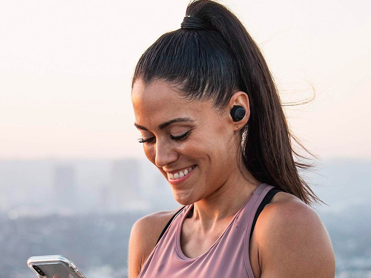 Woman wearing JLab Audio JBuds Air earbuds outside as one of the best tech products under $50