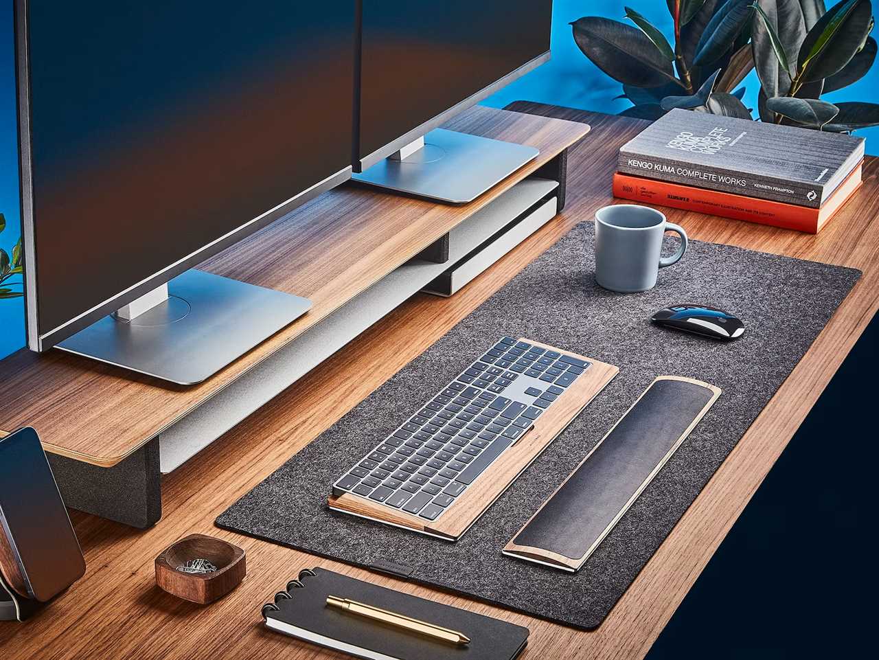 a Grovemade Wool Felt Desk Pad sits on a desk with a monitor, keyboard and so forth as one of the best tech products under $50